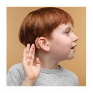 A child wearing a hearing device and his hand over his ear. 