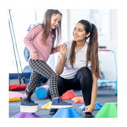 A child walking on colourful stepping stones while holding the hand of an adult.