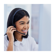 A women engaged in a call using a black headset on her head. She's got black hair and she's wearing a white blouse.