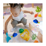 A small child playing on a sandpit, there are fish, bubbles and algae graphics on the photo.