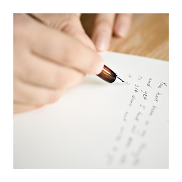 Close up of hand writing on a piece of paper.