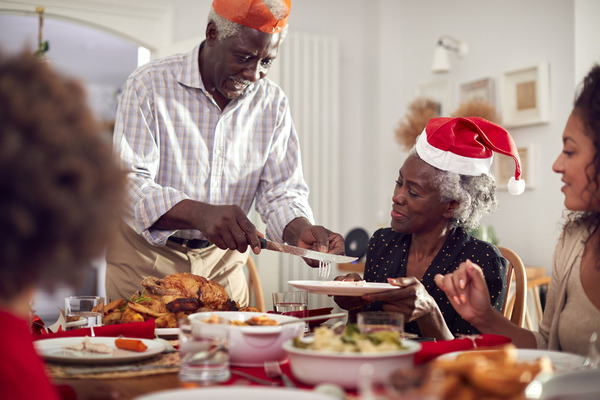 A multi-generational family sat around a table eating a Christmas dinner