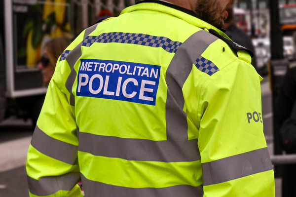 Metropolitan police officer in his vis jacket seen from behind