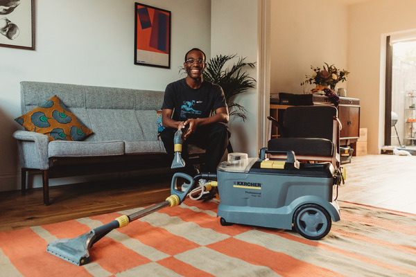 A man with a Karcher carpet cleaner