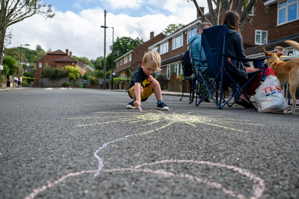 child playing with chalk on the street