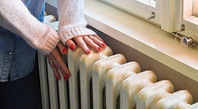 Image of hands warming by radiator.