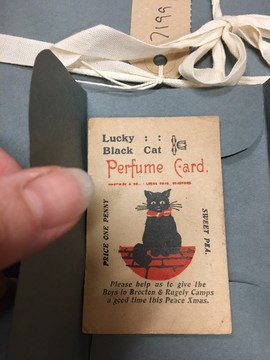 Luck Cat perfume card printed in red and black showing a black cat on a red mat
