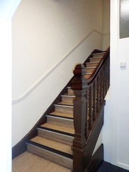Back staircase with curving wooden balustrade at Eastgate House