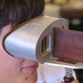 Colour photograph of woman looking into Victorian stereoscope