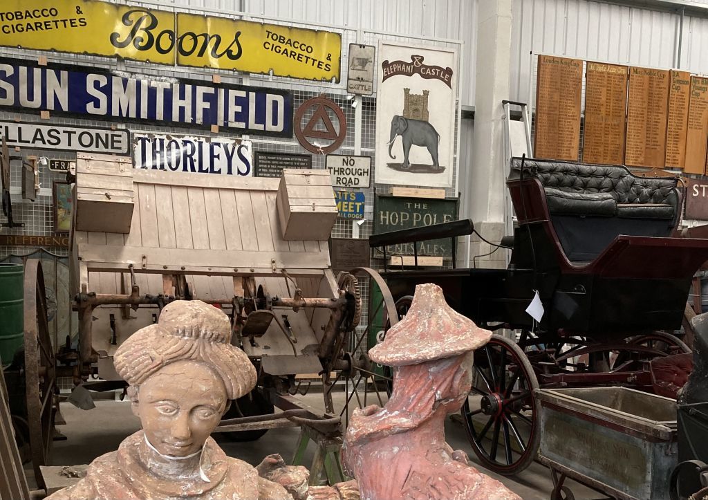 View of interior of collections store showing sculpture, carriages and enamel signs