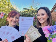 Two people holding wildflower seed packets and bookmarks