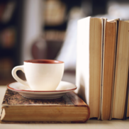 Cup and saucer next to some books