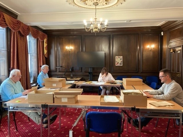 Volunteers researching, seated around a table at Eastgate House