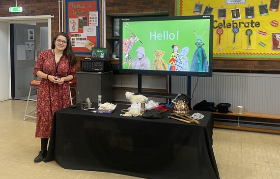 Team member standing next to collection of items used in the school assembly