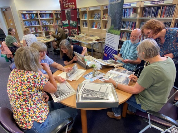 A group of people looking at old photos