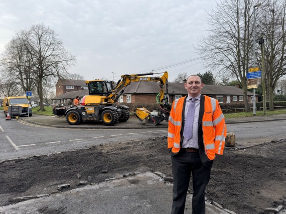 Rob Pritchard, standing with the JCB Pothole Pro as potholes get patched on Lichfield Street.