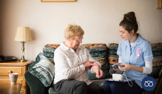 carer helping older lady on sofa