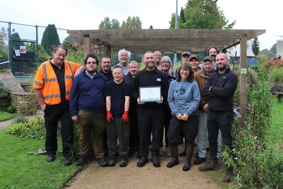 Volunteers and staff holding Britain in Bloom award at Stratford Park