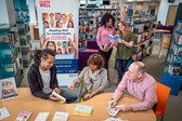 This is an image of people in a library to promote the Reading Well scheme