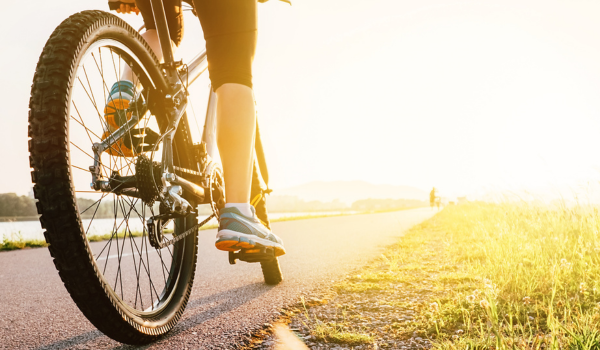 A women riding a bike with the sun setting