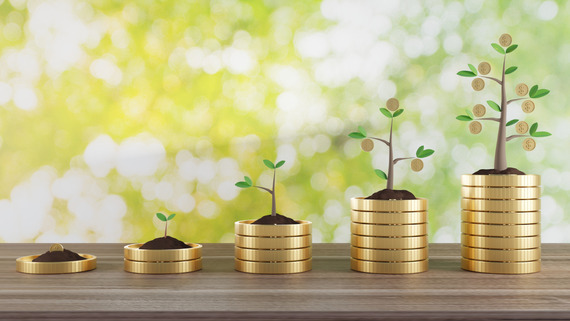 Abstract image of trees growing out of piles of coins.