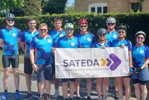 Photograph of cyclists from the 2025 mayor's bike ride, holding a banner which spells out SATEDA.