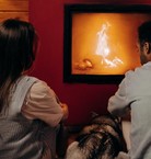 Couple heating by fire with dog