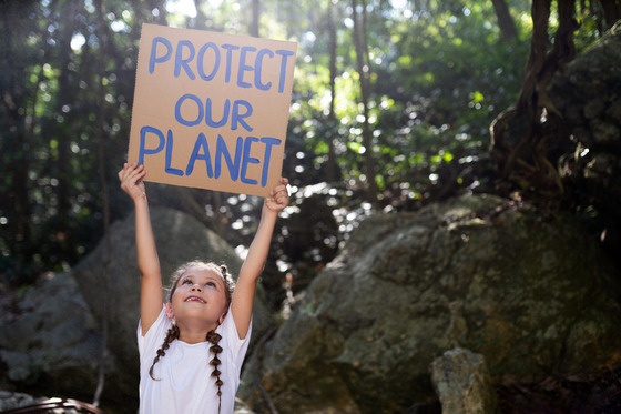child holding save the planet sign