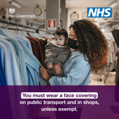 You must wear a face covering on public transport and in shops, unless exempt.  Lady with small child in arms shopping wearing face covering
