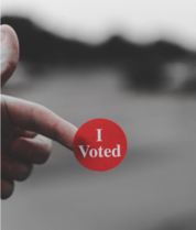finger pointing at a badge saying I voted