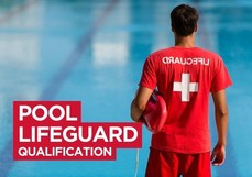 Pool Lifeguard qualification,  Guy standing by a swimming pool with a white cross and Lifeguard on back of a red shirt