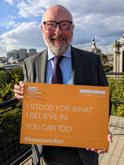 Cllr Alan Connett holding a sign saying: "I stood for what I believe in.  You can too #beacouncillor