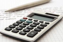 Calculator and pencil sitting on some papers