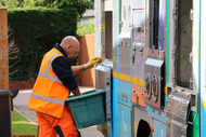 crew member loading recycling onto vehicle