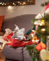Christmas wrapping paper on a sofa by a tree
