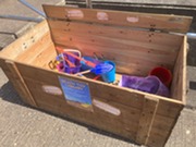A selection of beach toys in a wooden chest