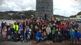 Volunteers in Teignbridge standing in front of brick tower