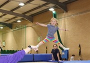 child with rainbow leggings bouncing on a trampoline