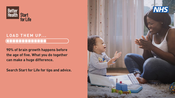 A young woman and baby sitting on the floor, clapping and smiling