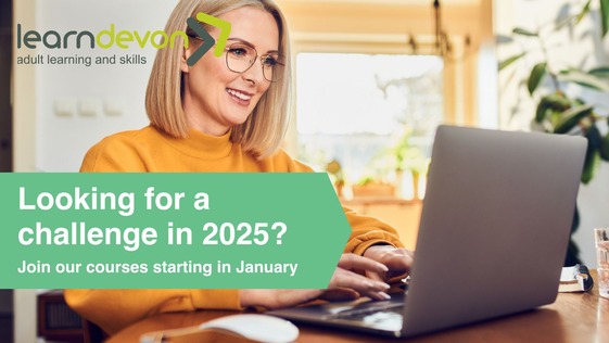 A woman in a yellow jumper looking at a laptop