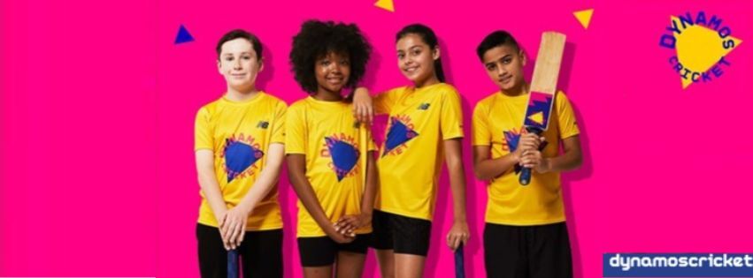 A group of children in yellow t-shirts holding cricket bats