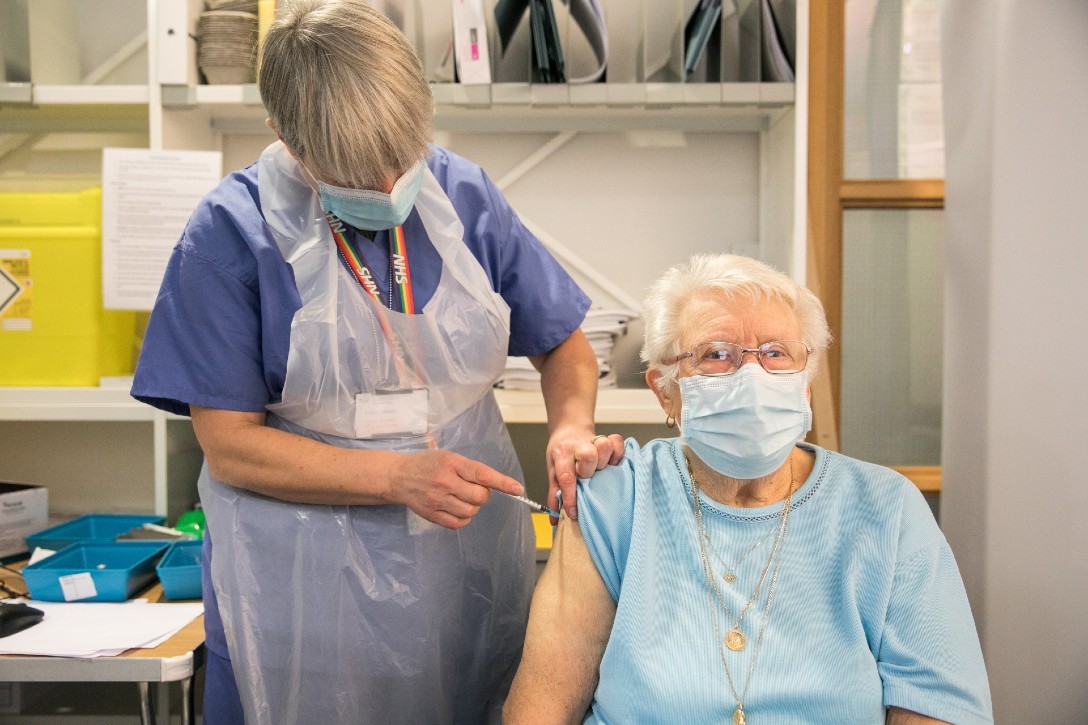 Elderly woman receiving a vaccine