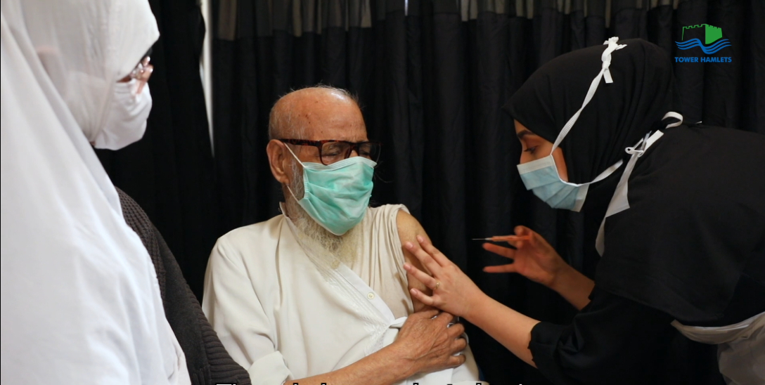 Photograph of a man receiving a Covid-19 vaccine in Tower Hamlets