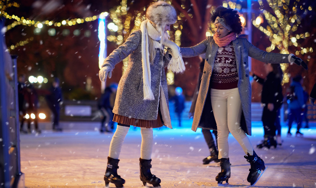 Two people ice skating in an ice rink