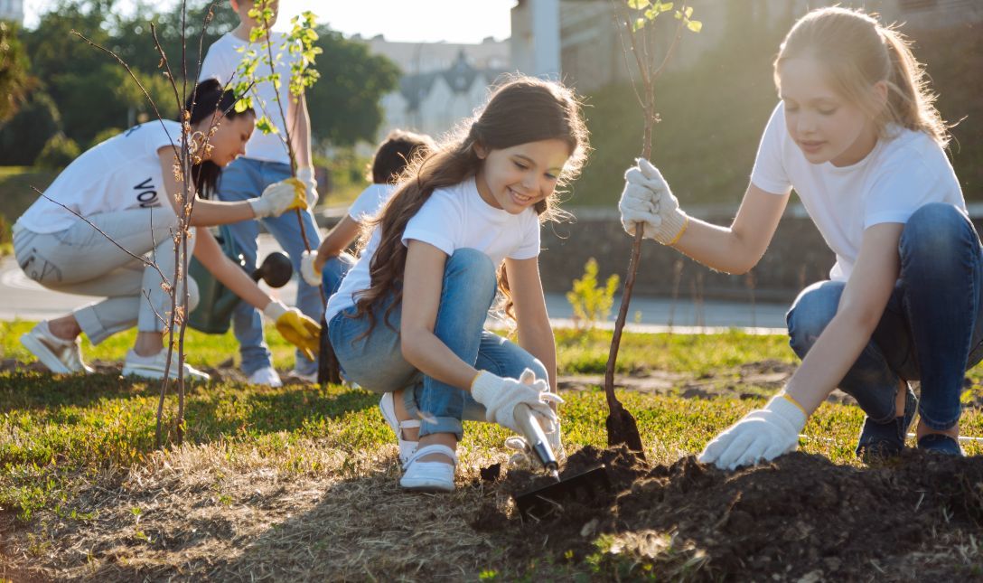 children planting trees in a garden