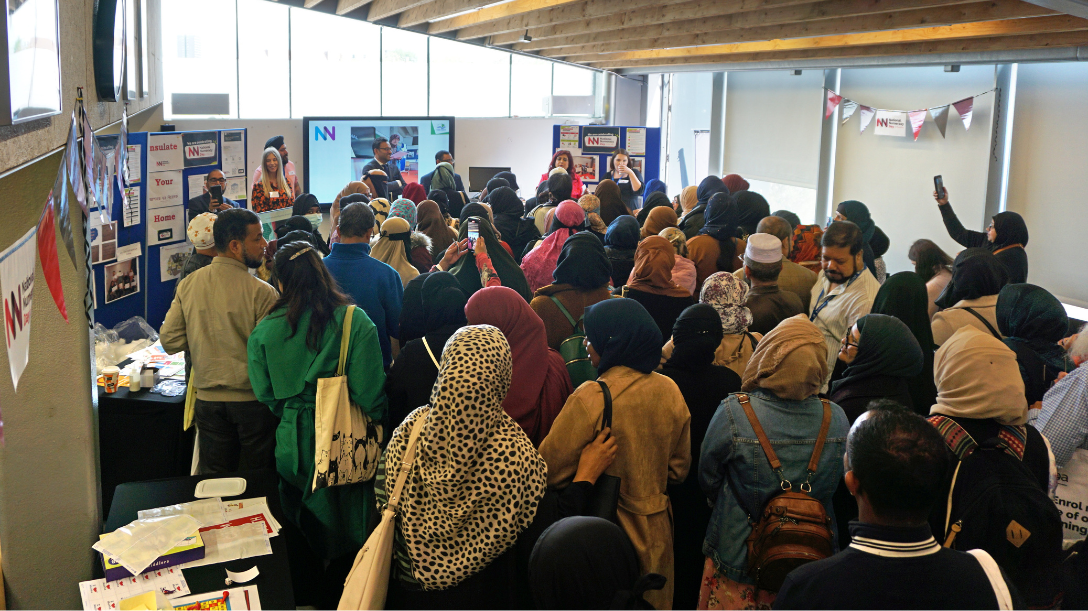 People standing around someone who is giving a presentation