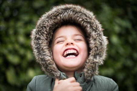 Boy in coat hood smiling