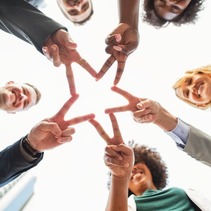 photograph of people joining hands together to make a star shape