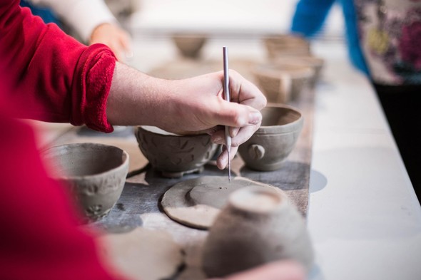 Hands creating clay tea cups