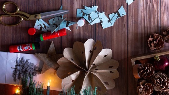 Paper, scissors and pinecones on a wooden tabletop in preparation for a craft session